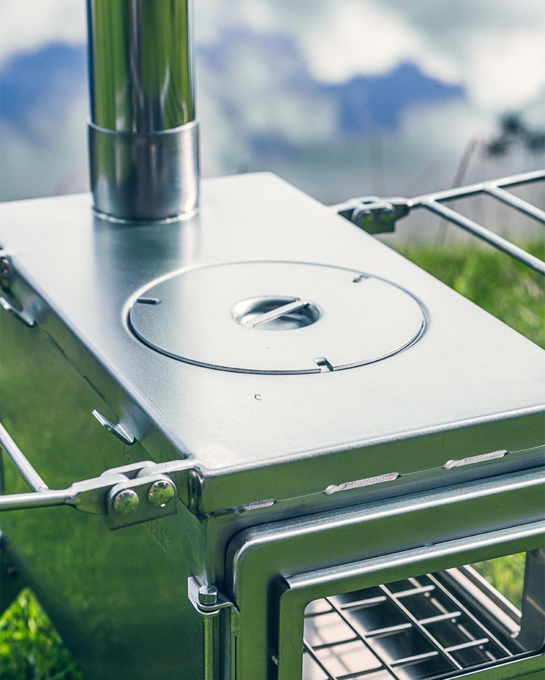 Stainless steel wood stove Winnerwell Nomad View cooking simple meal on camping stove in forest basecamp