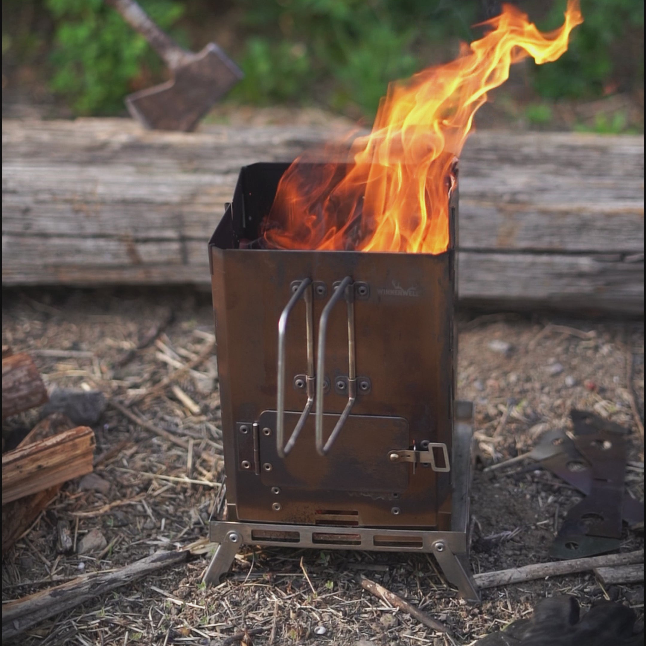 Winnerwell® Mini Multi - functional BBQ Smoker in outdoor use, burning wood/twigs to create heat for smoking meats, grilling food, or as a fire pit. Showcases its rugged design for camping, hiking, and off - grid cooking experiences.