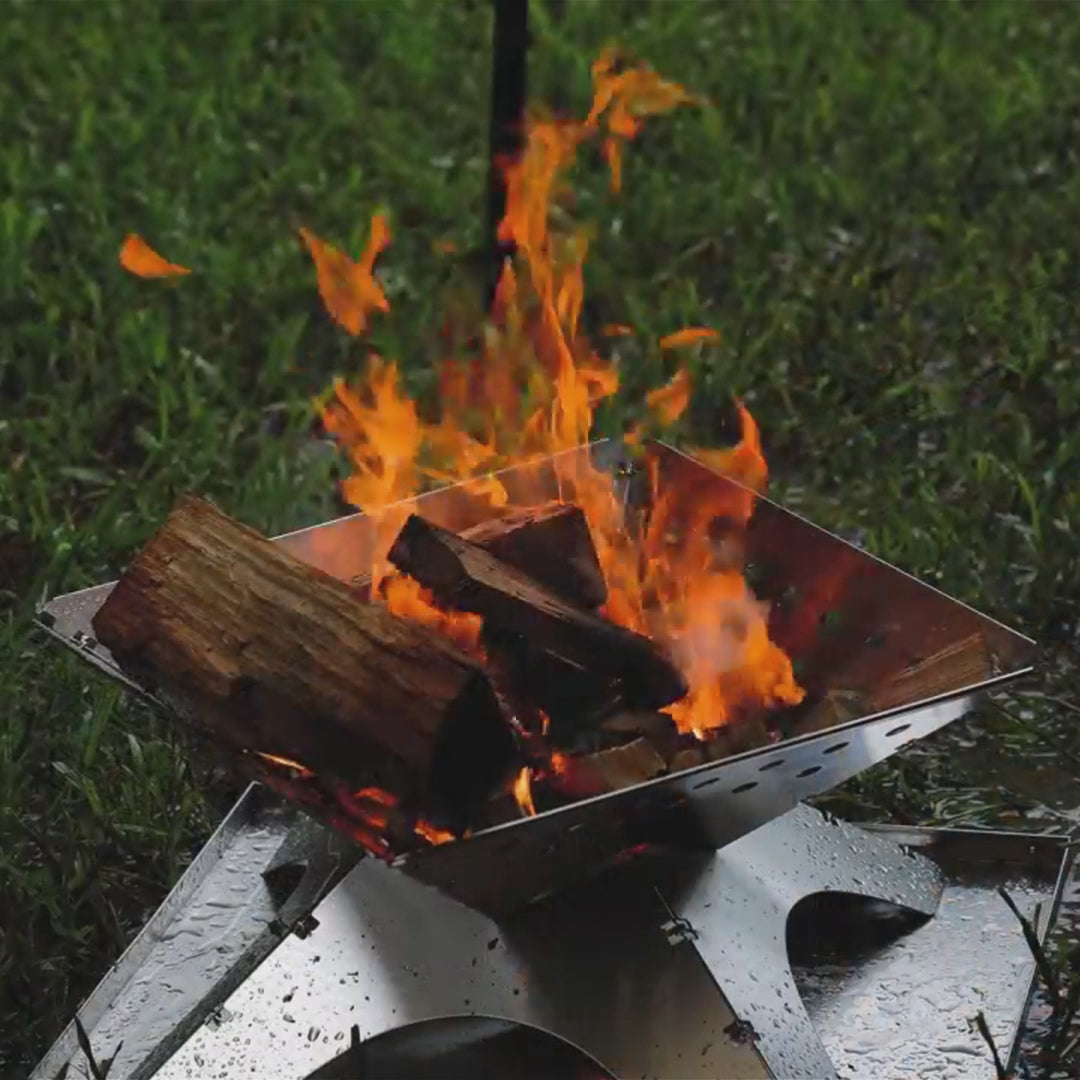 Winnerwell Flat Firepit in use, producing a bright and warm fire, ideal for providing heat during camping trips or outdoor evenings.