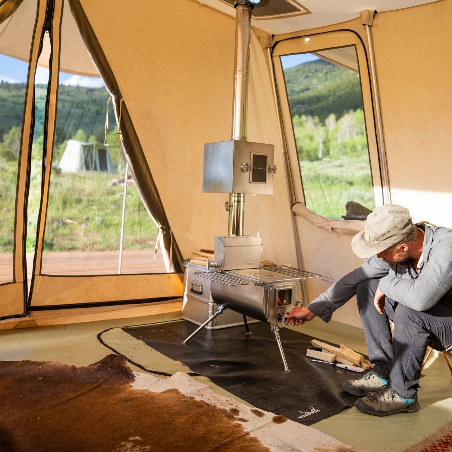 Winnerwell® Woodlander 1G Stove cooking in a camping tent—wood-burning design provides efficient heat, perfect for preparing meals during outdoor adventures.